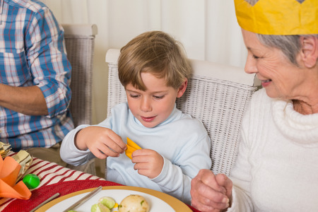 Portrait of grandmother and son in party hat at home in the living roomの写真素材