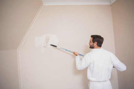 Painter painting the walls white in a new houseの写真素材