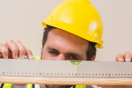 Construction worker using spirit level in a new houseの写真素材
