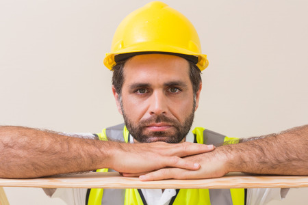 Stern construction worker looking at camera in a new houseの写真素材
