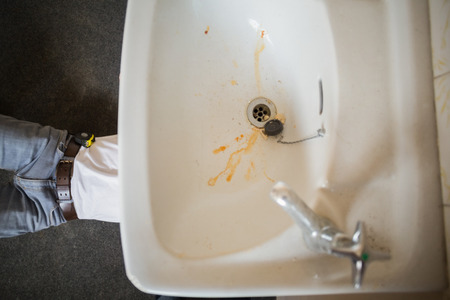 Plumber fixing the sink in a bathroom in a new houseの写真素材