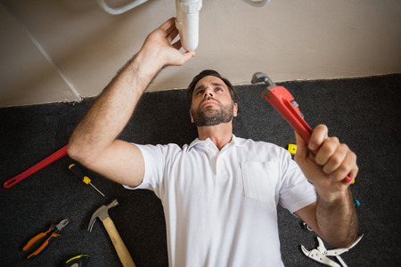 Plumber fixing the sink in a bathroom in a new house