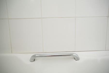 Metal handle in white bath in the bathroomの写真素材