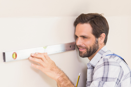 Construction worker using spirit level in a new house
