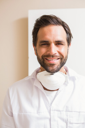 Carpenter wearing protective mask smiling at camera in a new houseの写真素材