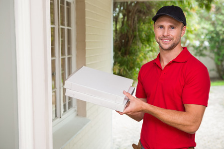 Pizza delivery man delivering pizzas to a houseの写真素材