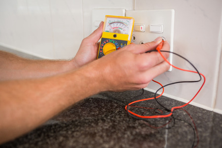 Metering voltage with digital multimeter in the kitchenの写真素材