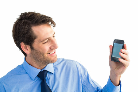 Smiling businessman showing smartphone to camera on white backgroundの写真素材