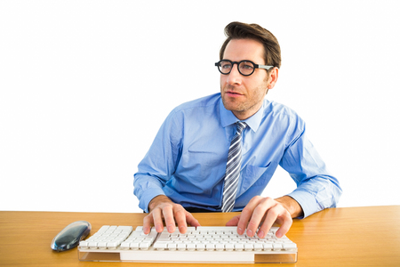 Businessman typing on his keyboard wearing glasses on white backgroundの写真素材