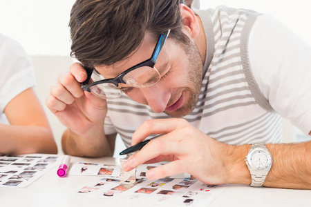 Photo editor using a magnifying loupe in officeの写真素材