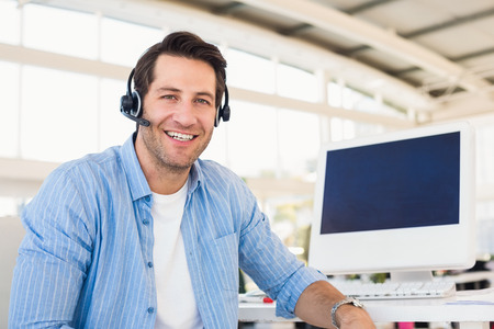 Portrait of a smiling photo editor wearing a headset in office