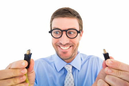 Geeky businessman holding two cables on white backgroundの写真素材