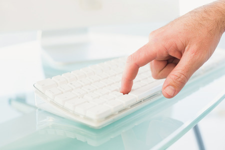 Businessman pushing key on keyboard in his office