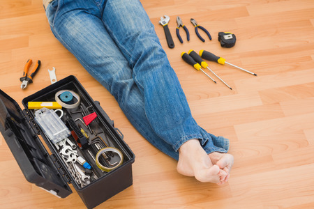 Man legs with toolbox on floor at home in the living roomの写真素材