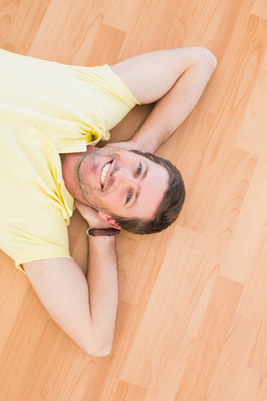 A man lying on floor at home in the living roomの写真素材