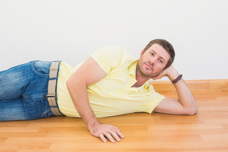 Man lying on floor at home in the living roomの写真素材