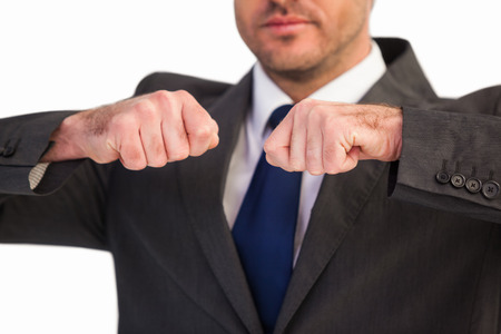 Mid section of a businessman with clenched fist on white backgroundの写真素材