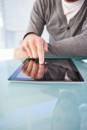 Mid section of businessman using digital tablet at desk in the officeの写真素材