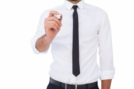 Focused businessman writing with marker on white backgroundの写真素材