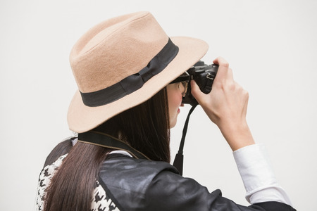 Pretty hipster taking a photo against bleached wooden planksの写真素材