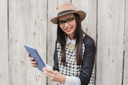 Pretty hipster using tablet pc against bleached wooden planksの写真素材