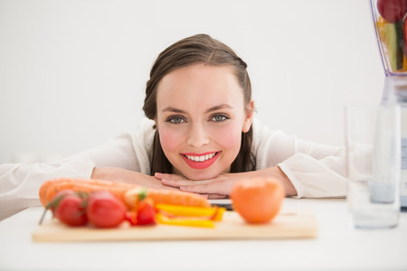 Pretty brunette preparing a healthy juice at home in the kitchenの写真素材