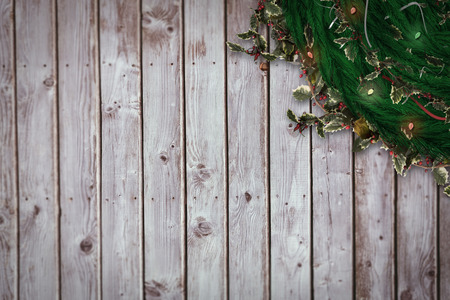Festive christmas wreath with decorations against digitally generated grey wooden planksの写真素材