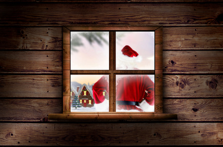 Santa delivery presents to village against window in wooden roomの写真素材