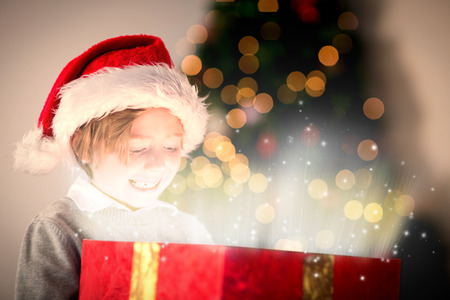 Child opening his christmas present against snowの写真素材