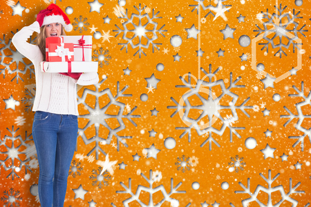 Festive blonde holding pile of gifts against snowflake wallpaper patternの写真素材