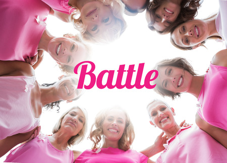 Happy women smiling in circle wearing pink for breast cancer on white backgroundの写真素材