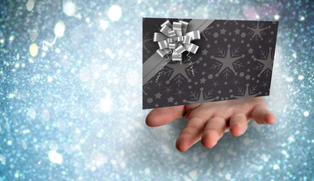 Hand bursting through paper against white snow and stars designの写真素材