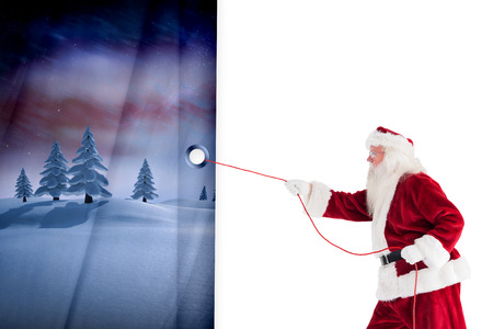 Santa pulls something with a rope against white curtain blindの写真素材