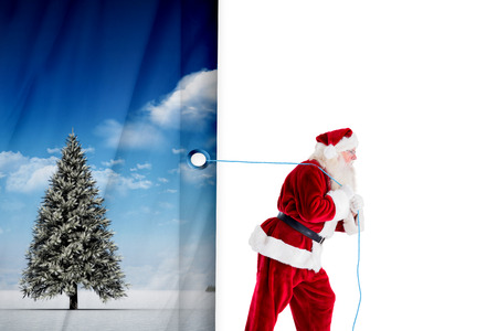 Santa claus pulling rope against white curtain blindの写真素材