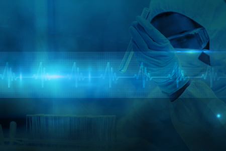 Protected scientist looking at a dangerous liquid in test tubes against ecg line in blue and blackの写真素材