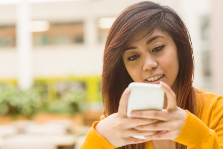 Close up of beautiful young woman text messagingの写真素材