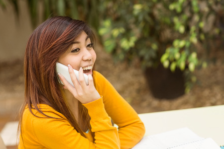 Side view of young woman using mobile phone in the parkの写真素材