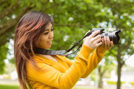Side view of beautiful female photographer at the park