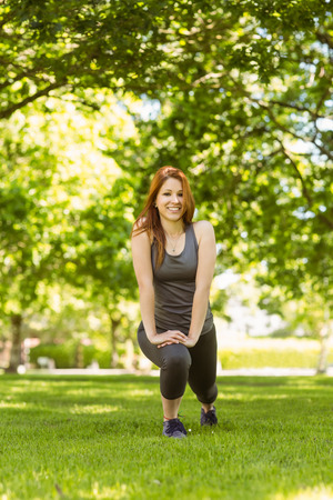Portrait of a pretty redhead stretching on a sunny dayの写真素材