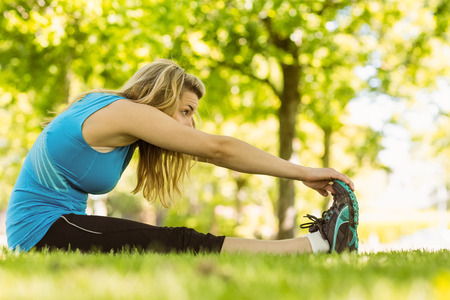 Fit blonde stretching in the park on a sunny dayの写真素材