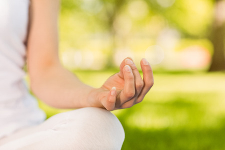 Peaceful woman doing yoga in the park on a sunny dayの写真素材