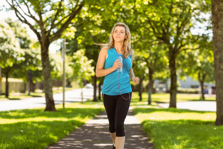 Fit blonde jogging in the park on a sunny dayの写真素材