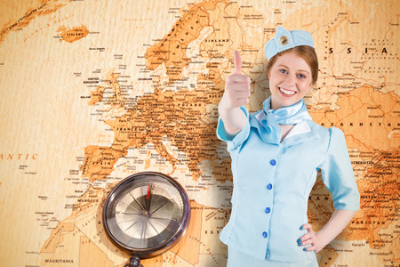 Pretty air hostess with hand on hip against world map with compass showing europe and the middle...