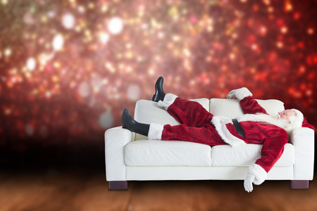 Santa Claus taking a nap against shimmering light design over boardsの写真素材