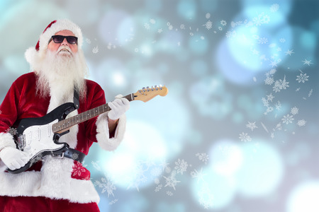 Santa Claus plays guitar with sunglasses against light glowing dots design patternの写真素材