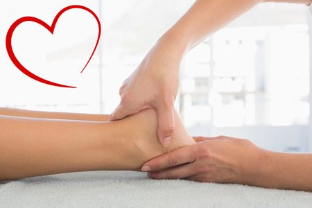 Woman receiving leg massage at spa center against heartの写真素材