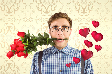 Geeky hipster biting a bunch of roses against elegant patterned wallpaper in cream tonesの写真素材