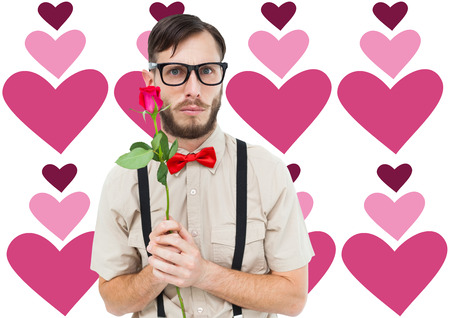 Geeky hipster offering a rose against valentines day patternの写真素材