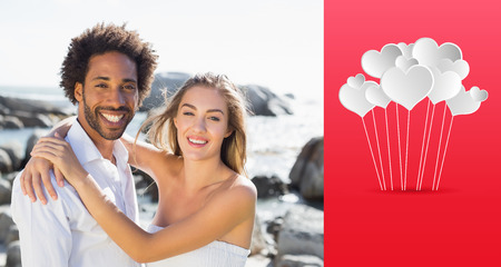 Gorgeous couple embracing by the coast against heartsの写真素材