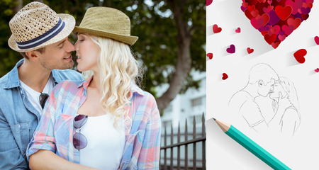 Hip young couple kissing by railings against sketch of kissing couple with pencilの写真素材